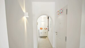 A narrow hallway with white walls and a tiled floor leading to a door with a decorative item above it. - Mimosa - pretty holiday property with private pool in Moraira (Benissa)