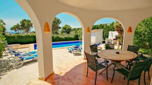 A covered outdoor area with a pool, lounge chairs, and a table with chairs. - Mimosa - pretty holiday property with private pool in Moraira (Benissa)