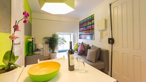 A modern living room with a green bowl, a wine bottle, and a colorful artwork on the wall. - Contemporary by Apartments Alfama (Lisbon)