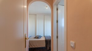 Un dormitorio con cama, una puerta y un interruptor de luz.