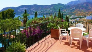 Une terrasse offrant une vue sur les montagnes et un plan d’eau.