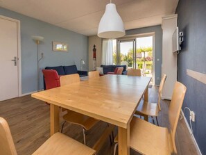 Enjoy communal dining in this spacious room with a large table and six chairs, surrounded by a view of the outdoors.