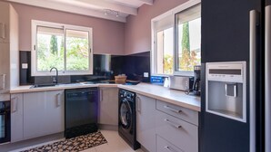 A modern kitchen with a dishwasher, washing machine, and a water dispenser. - Villa in Callian with Heated Pool and Terrace (Callian)