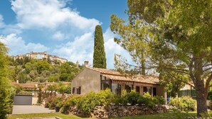 A Mediterranean-style villa with a tiled roof, surrounded by lush greenery and a stone wall. - Villa in Callian with Heated Pool and Terrace (Callian)