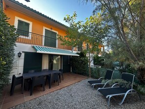A patio with a table and chairs, a covered seating area, and a building with a balcony. - Daró 3D 39 - 150m from the beach, with pool (Torroella de Montgri)