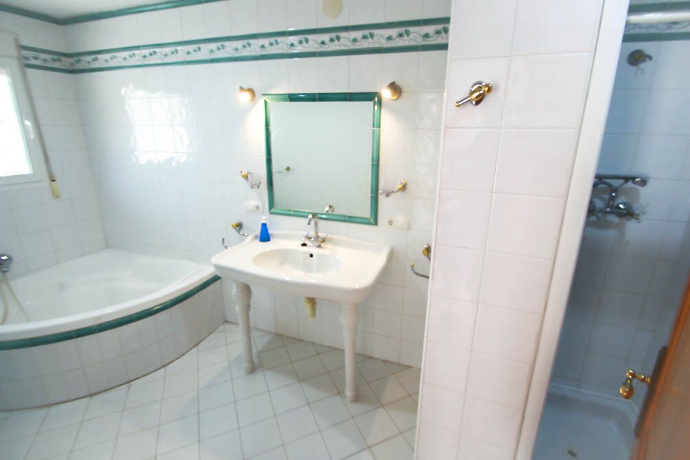 A bathroom with a bathtub, sink, and shower.