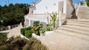 A white building with a tiled roof, a balcony, and a staircase leading up to it. - Sesam - sea view villa with private pool in Moraira (Teulada)