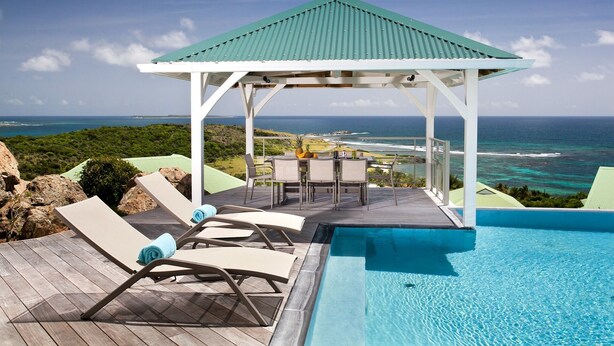 A pool area with lounge chairs and a gazebo overlooking a coastal view. - Le Bougainvillier, magnificent villa with breathtaking views (Oyster Pond)