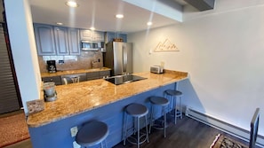 Enjoy cooking in this well-equipped kitchen with a sink, refrigerator, and microwave.