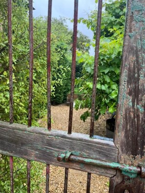 A rustic wooden fence with metal bars, surrounded by greenery. - Elm Cottage Barn (Oatlands)