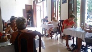 A restaurant with indoor seating, tables, chairs, and a view of the outdoors. - Nhi Trung Hotel (Da Nang)