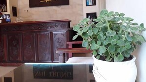 A reception desk with a sign reading "NH TRUNG Hotel" and a potted plant to the right. - Nhi Trung Hotel (Da Nang)