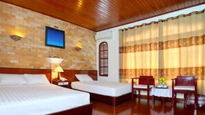 A hotel room with two beds, a wooden ceiling, a brick wall, a TV, and a window with curtains. - Nhi Trung Hotel (Da Nang)