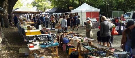 Un mercado al aire libre con varios puestos que venden herramientas y libros.