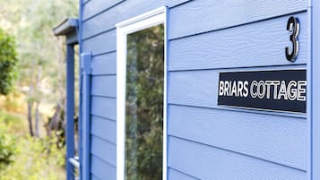 A house with a sign reading "Briars Cottage" and the number "3" on the door.