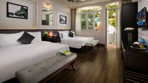 A hotel room with two beds, a bench, a TV, and a window with a view of the outside. - Golden Rooster Hotel (Hanoi)