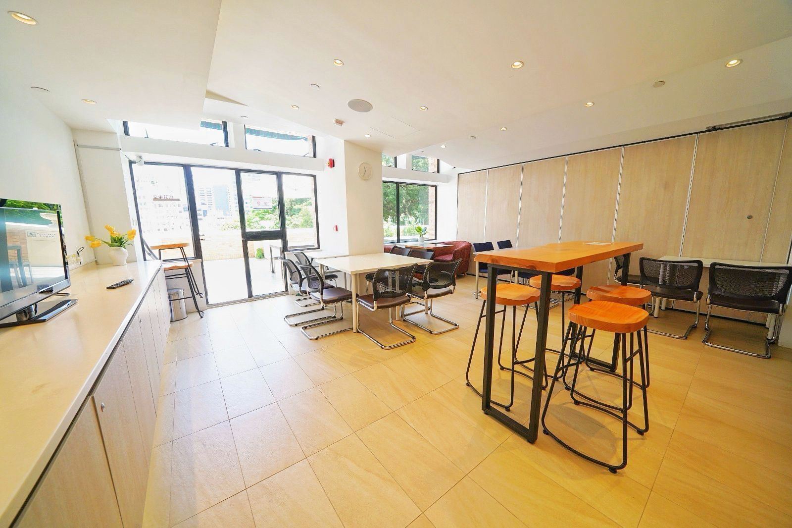 A modern kitchen with a large island, bar stools, and a television.