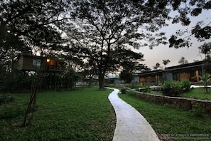 Un chemin menant à un bâtiment, avec des arbres en arrière-plan.