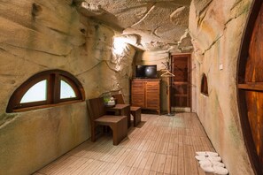 Une pièce rustique avec un meuble en bois, un téléviseur et une porte en bois.