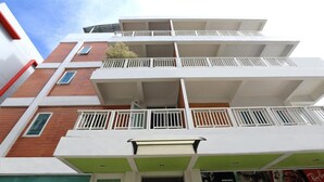 A multi-story building with balconies, a green awning, and a visible entrance. - SK Resort (Bangkok)