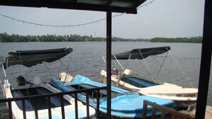 A covered boat dock with two boats, one with a canopy. - Mahi Villa (Bentota)
