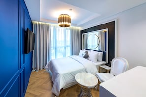 A modern hotel room with a large bed, a bedside table, a chair, and a TV mounted on the wall. - Hotel the Designers DDP (Seoul)