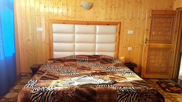 Cozy retreat with a large bed, wooden paneling, and a decorative door featuring geometric patterns.