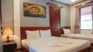 Ein Hotelzimmer mit zwei Betten, einem hölzernen Kopfteil, einem Bild an der Wand und einem Fenster mit Vorhängen.