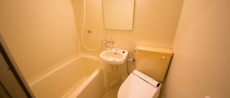A small bathroom with a bathtub, a sink, and a toilet.