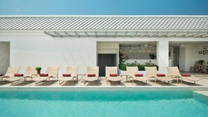 Ein Poolbereich mit Liegestühlen und einem klaren, blauen Pool.