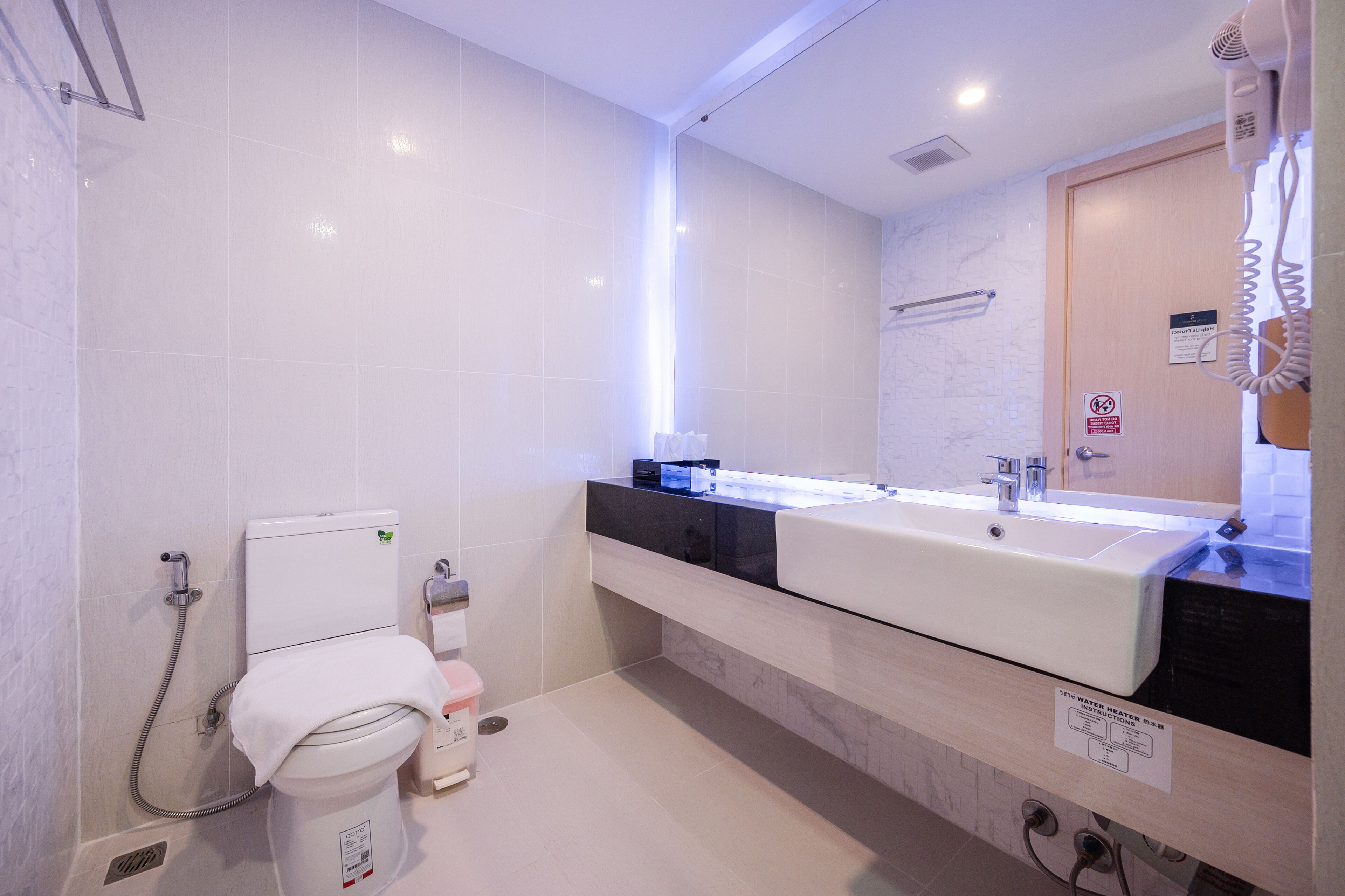 A modern bathroom with a dual sink, toilet, and shower.