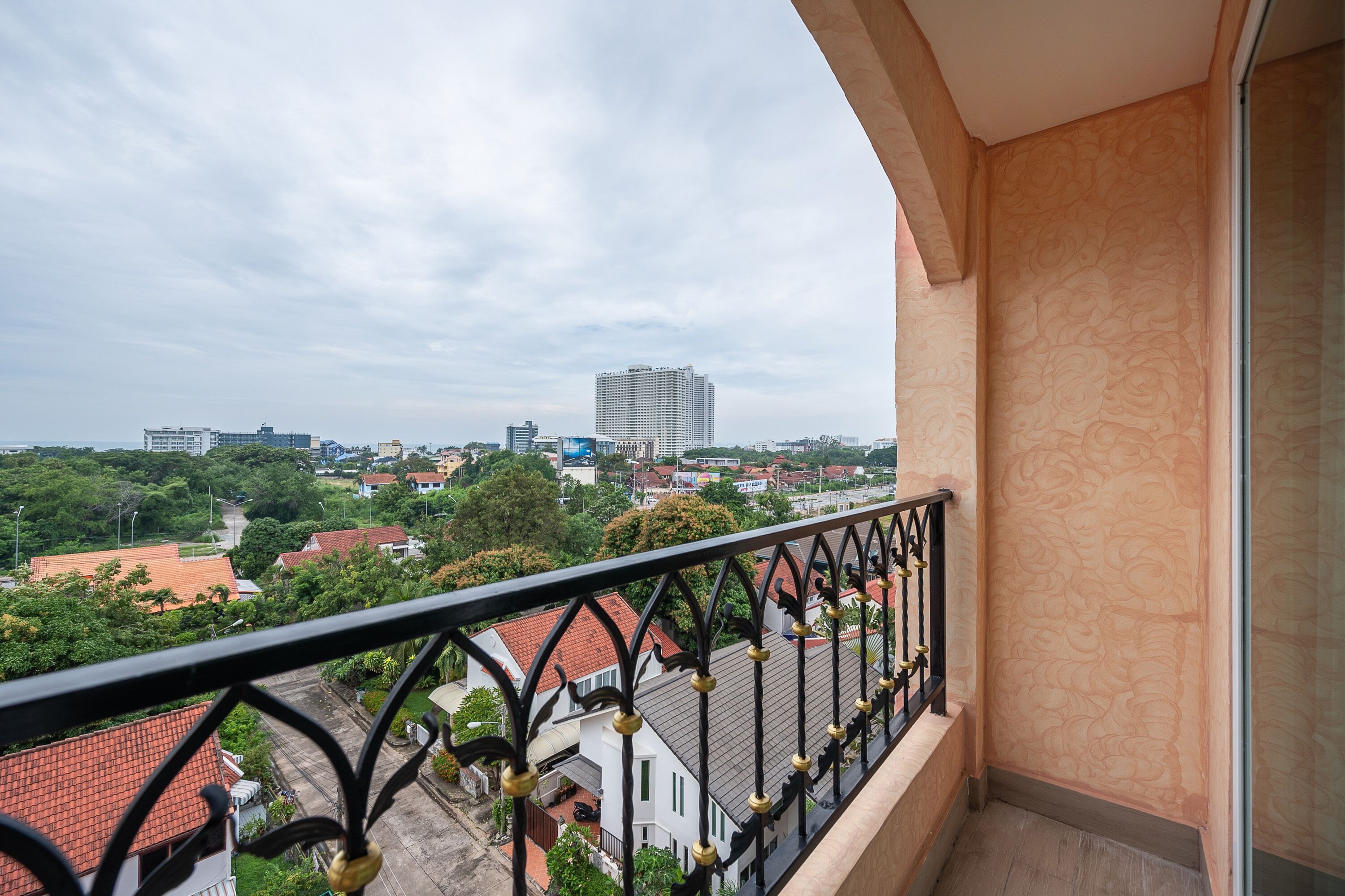 Ein Balkon mit Blick auf eine Stadtlandschaft, einschließlich Gebäude und Grünflächen.