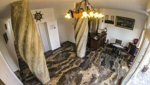 A room with a stone-like floor, a chandelier, a desk, and a chair. - Family Hotel Sirena Palace (Obzor)