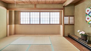 Une pièce de style japonais traditionnel, avec des tatamis, un paravent shoji et une porte shoji suspendue.