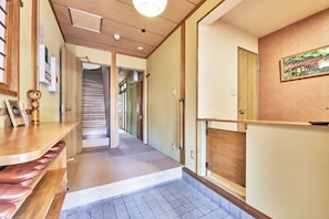 Guests can sit on the bench and enjoy the framed artwork and clock in this welcoming corridor.
