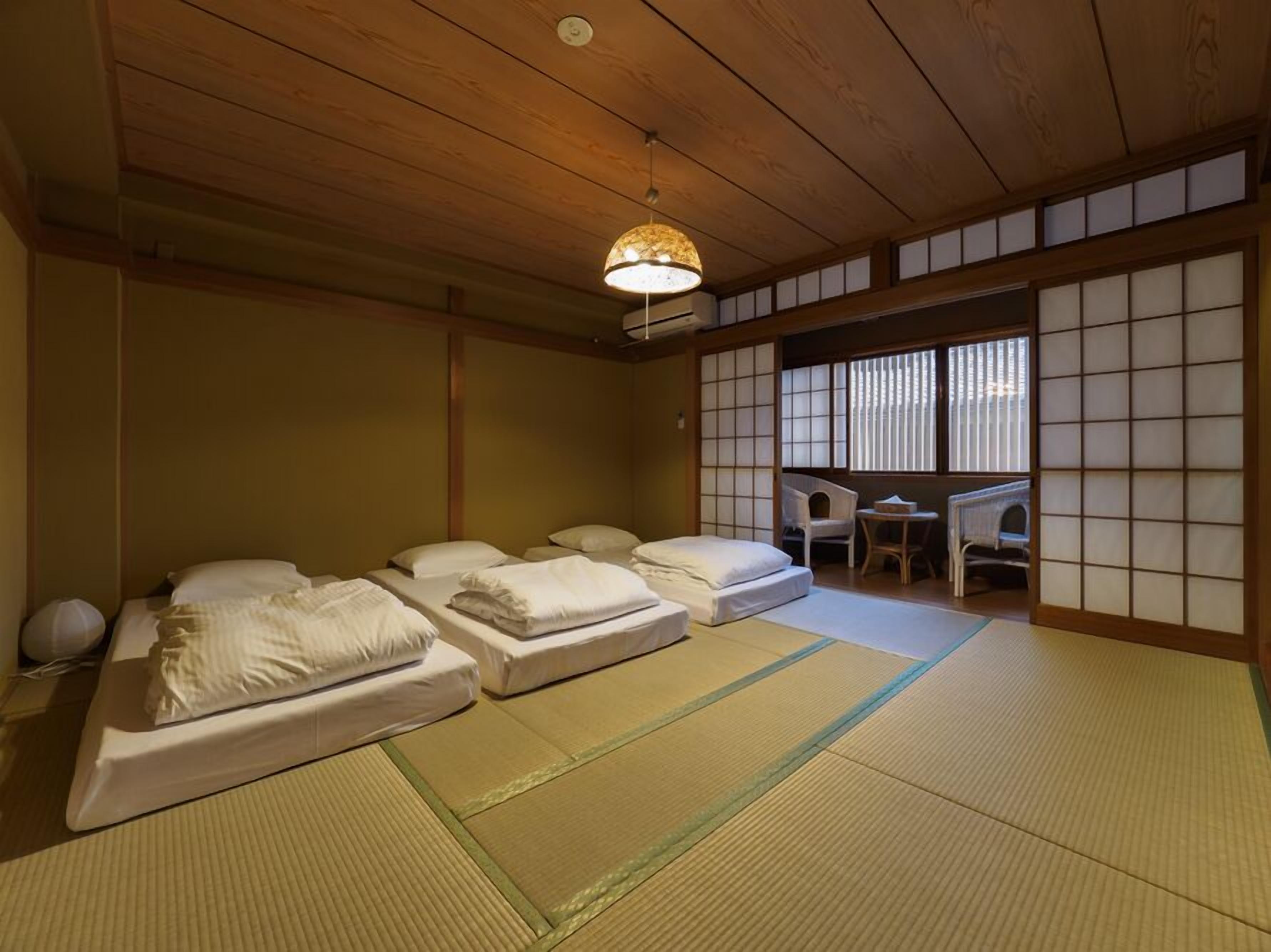 A traditional Japanese room with tatami flooring, a low ceiling, and sliding shoji doors.
