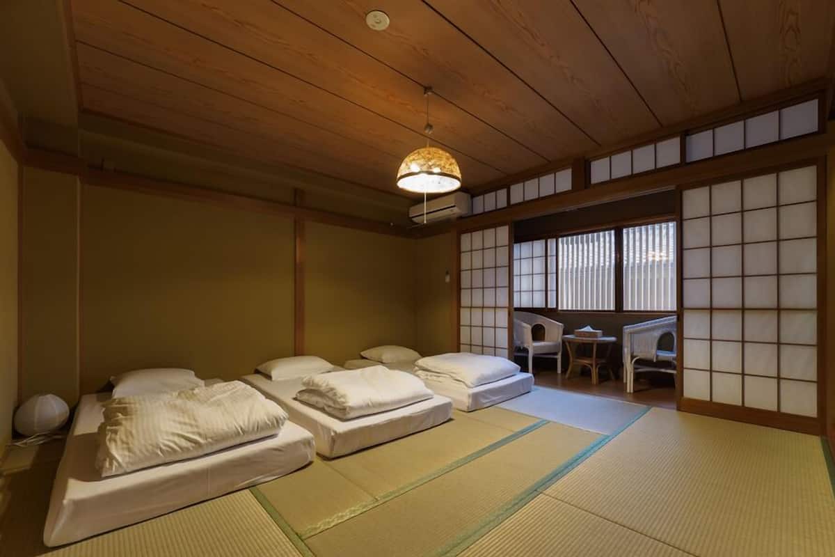 Une pièce de style japonais traditionnel, avec un sol recouvert de tatamis, un plafond bas et des portes coulissantes en papier de riz (shoji).