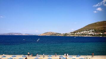 Di pantai, kursi berjemur, dan payung pantai