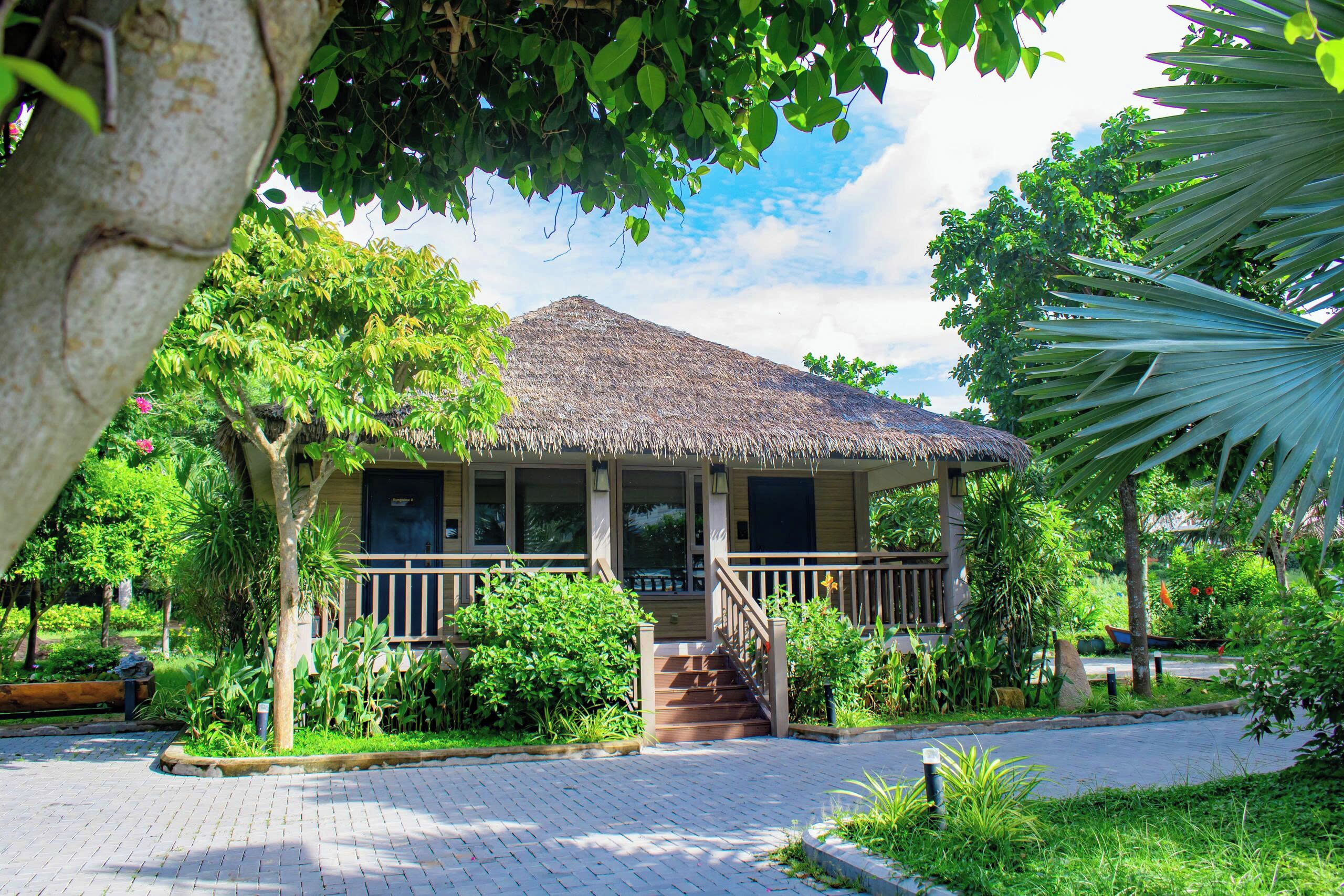 A thatched-roof building with a wooden porch and steps leading to the entrance.