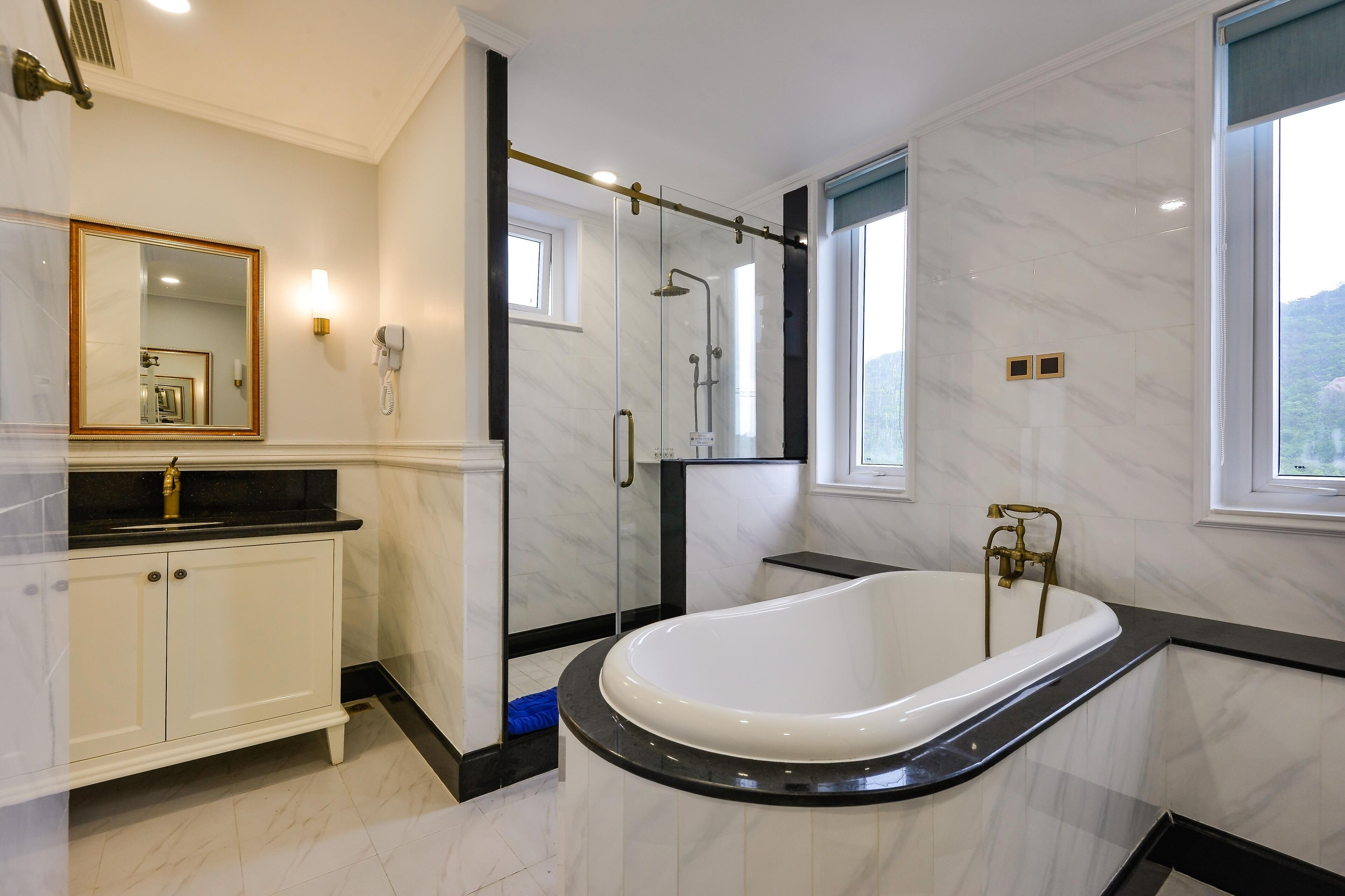 Un bagno moderno con una vasca freestanding, una cabina doccia in vetro e un mobile lavabo con specchio.