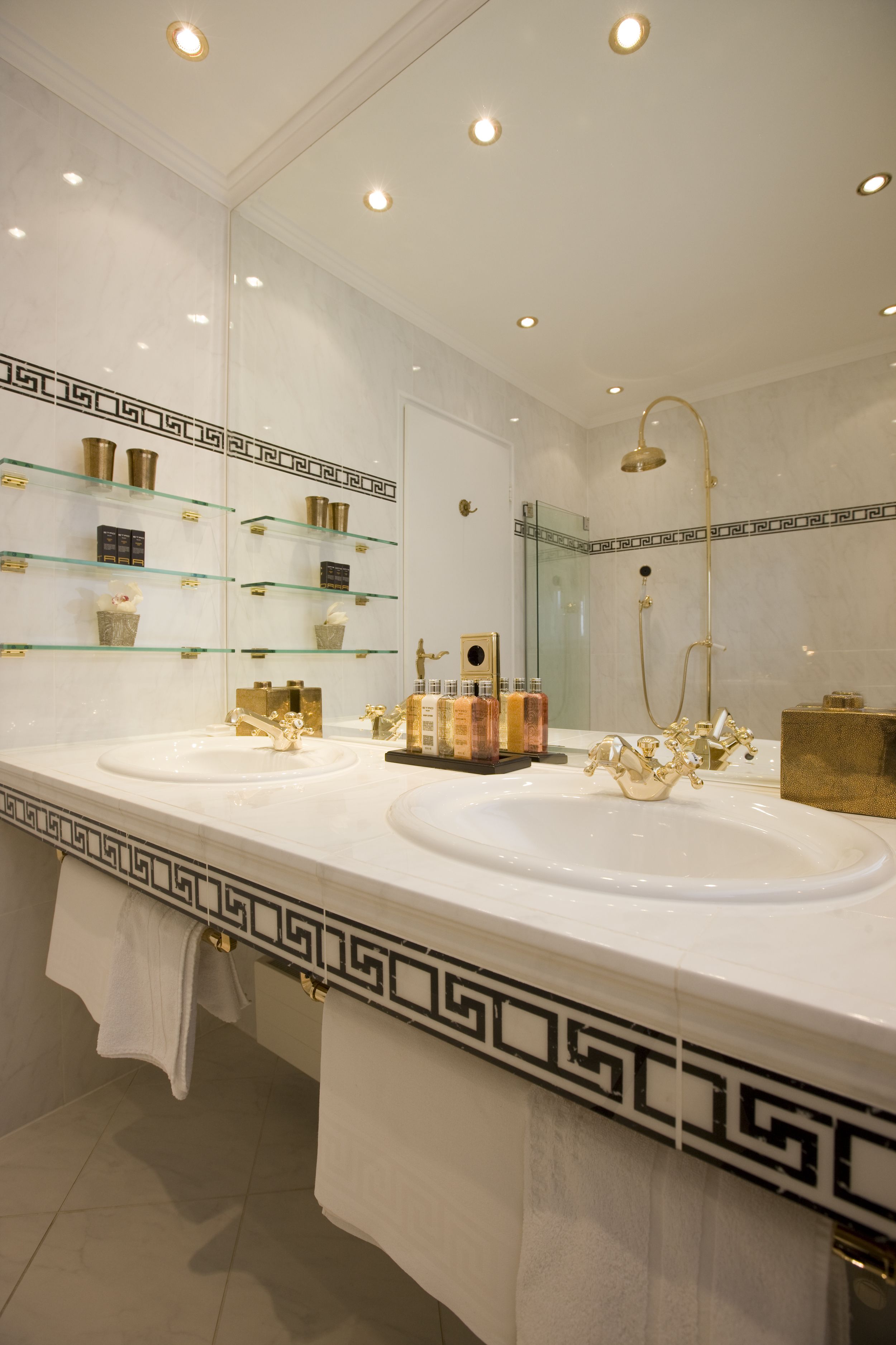 Un baño con dos lavamanos, un espejo grande y una ducha.