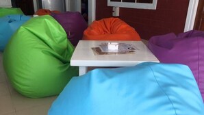 Um quarto com poltronas de espuma coloridas e uma mesa branca.