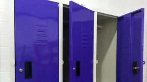 Três armários roxos com um fundo de parede em azulejos brancos.