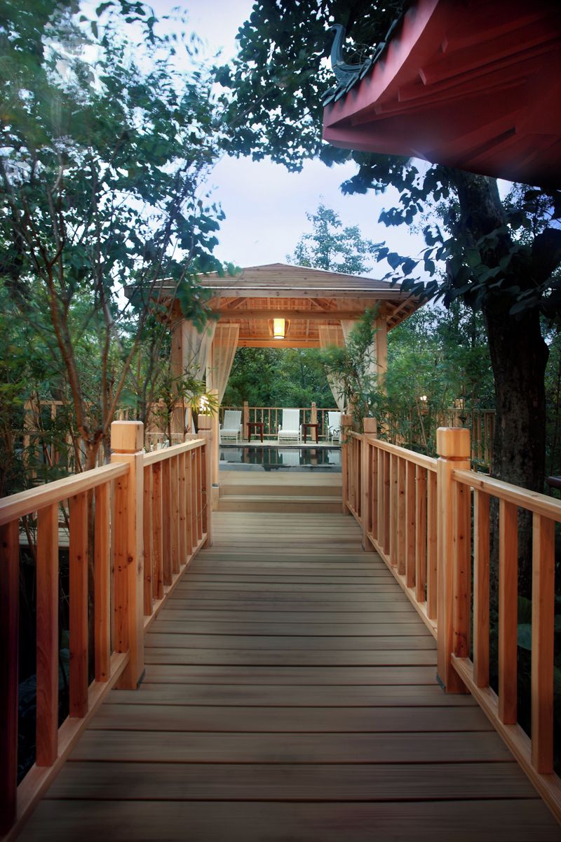 Una terraza de madera que da a un área cubierta con piscina.