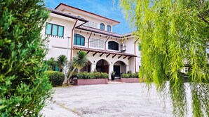 A two-story building with a tiled roof, arched entrance, and a paved driveway. - Villa 223 (Bandar Baru Bangi)