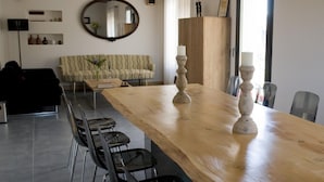 A dining area with a long wooden table, chairs, and a mirror on the wall. - La Baranda (Chulilla)