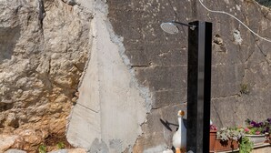 A stone wall with a tiled floor and a metal structure, possibly a shower enclosure. - Guest House Kusalo (Dubrovnik)