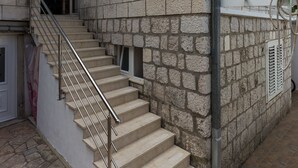 A stone building with a staircase leading to an entrance. - Guest House Kusalo (Dubrovnik)