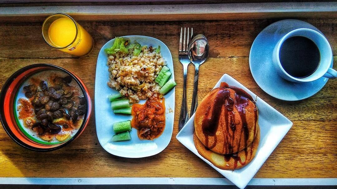 A meal tray with rice, vegetables, a bowl of soup, and a plate of meat.