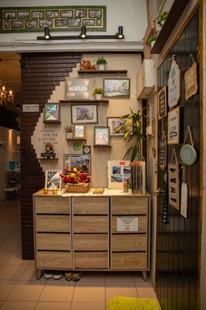 A reception desk with framed photos, a 'Beatles' sign, and a 'Thank you for staying with us' sign. - Escape Backpackers KK (Kota Kinabalu)